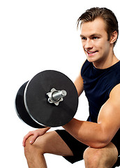 Image showing Strong young man working out with dumbbells