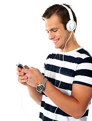 Image showing Male teenager with mp3 player and earbuds