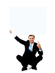 Image showing Business professional pointing up towards blank placard
