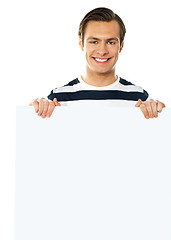 Image showing Casual young man holding a blank poster