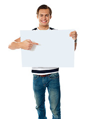 Image showing Portrait of young man pointing at blank signboard