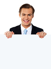 Image showing Cool businessman holding a blank poster