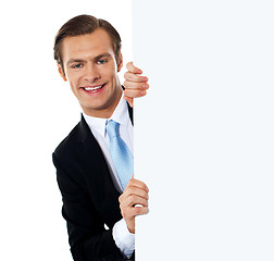 Image showing Smiling business professional behind blank clipboard