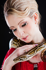 Image showing attractive blond woman with python on black