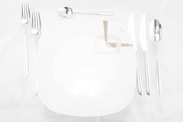 Image showing Plates with a silver fork, spoon, dessert spoon and a knife 