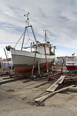 Image showing small vessel in dry dock with cloudy sky in background