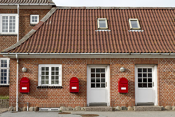 Image showing red mailboxes on stone walled house