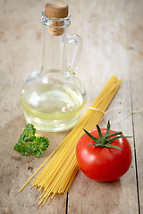 Image showing tomato and spaghetti on old wooden table