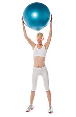 Image showing Sporty woman holding ball over her head