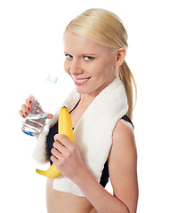 Image showing Fitness girl holding water bottle and banana
