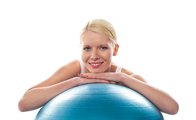 Image showing Attractive fit young woman resting chin over ball