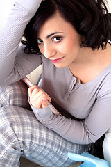 Image showing beautiful woman is sitting on the sofa an reading a book 