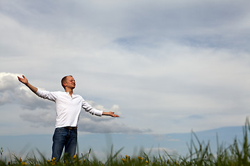 Image showing man is standing outside in spring with arms wide open and breathing