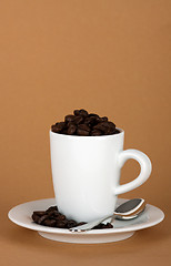 Image showing white coffe cup with coffe beans and a silver spoon