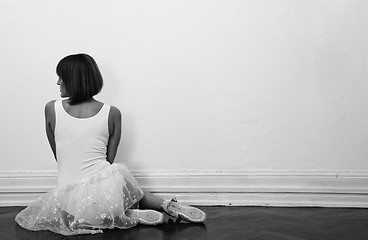 Image showing beautiful ballerina is sitting on the floor in black and white