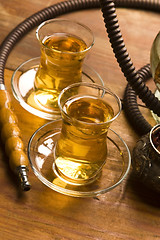 Image showing Cup of turkish tea and hookah served in traditional style