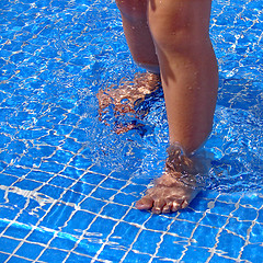 Image showing Baby's feet in swimming pool