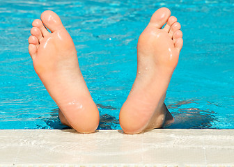 Image showing Man's feet with bright blue swimming pool background