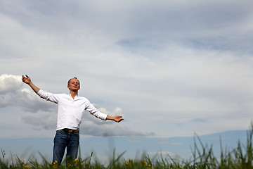 Image showing man is standing outside in spring with arms wide open and breathing