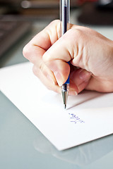 Image showing womans hand is writing a letter with a pen 