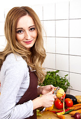 Image showing young beautiful housewife is cooking with fresh vegetables
