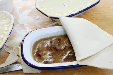 Image showing Adding pastry to a pie