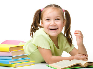 Image showing Cute little girl is reading a book