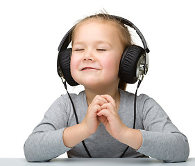 Image showing Cute little girl enjoying music using headphones