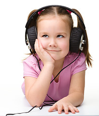 Image showing Cute little girl enjoying music using headphones