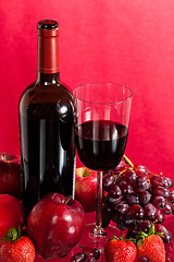 Image showing Red wine bottle and fruit with glass