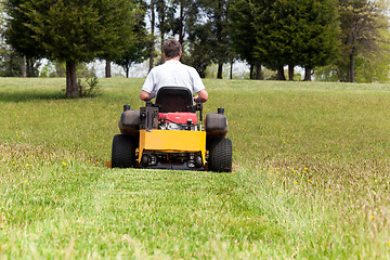 Image showing Senior man on zero turn lawn mower on turf