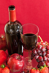 Image showing Red wine bottle and fruit with glass