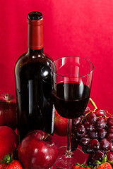 Image showing Red wine bottle and fruit with glass