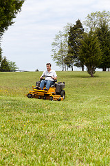 Image showing Senior man on zero turn lawn mower on turf