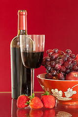 Image showing Red wine bottle and fruit with glass