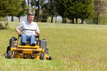 Image showing Senior man on zero turn lawn mower on turf