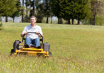 Image showing Senior man on zero turn lawn mower on turf