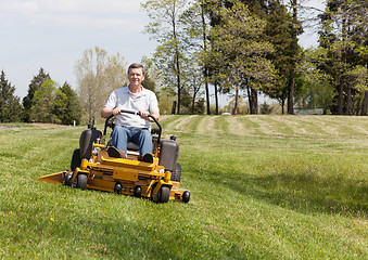 Image showing Senior man on zero turn lawn mower on turf