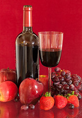 Image showing Red wine bottle and fruit with glass