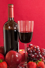 Image showing Red wine bottle and fruit with glass