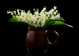 Image showing Bouquet lilies of the valley in a ceramic mug.