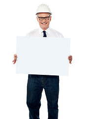 Image showing Senior architect holding blank billboard