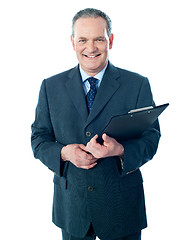 Image showing Smiling elderly businessman holding clipboard