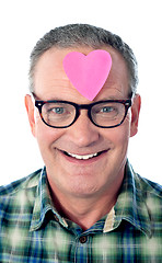 Image showing Handsome senior man with paper heart on his forehead