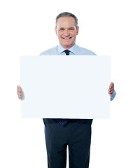 Image showing Handsome man holding blank white billboard