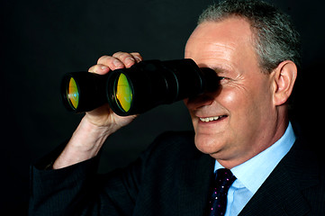 Image showing Aged executive monitoring through binoculars