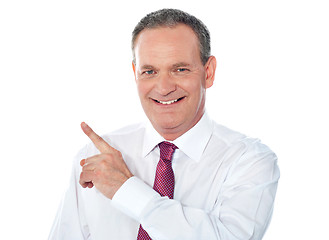 Image showing Smiling businessman pointing away