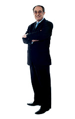 Image showing Smiling senior executive posing with folded arms