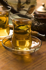 Image showing Cup of turkish tea and hookah served in traditional style