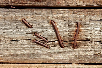 Image showing Rusty nails in wooden shield